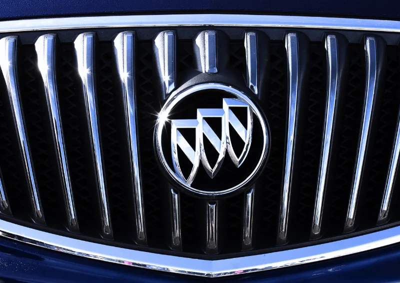 Buick emblem centered on a chrome vertical slat grille close-up